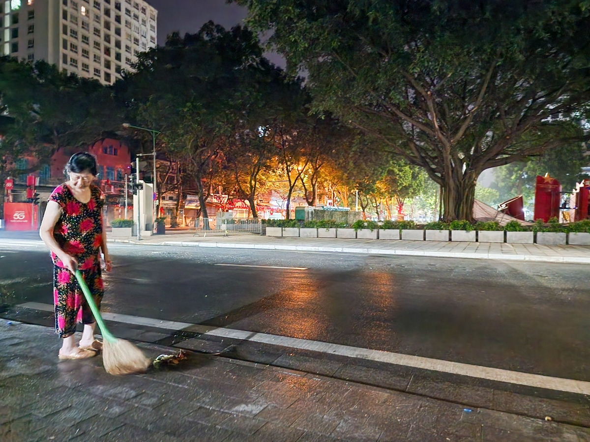Bà Lê Tường Vân mang chổi ra quét vỉa hè. Ảnh: Dương Đình Tường. Bà Lê Tường Vân mang chổi ra quét vỉa hè. Ảnh: Dương Đình Tường.