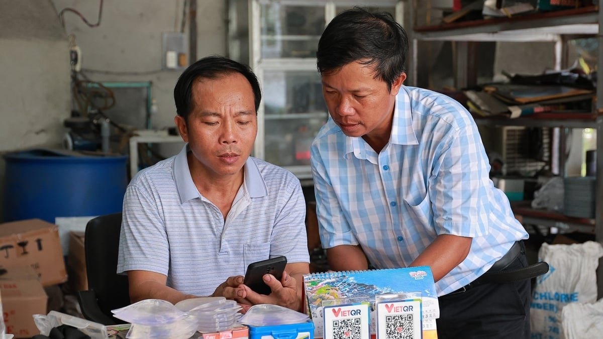 Ông Đào Văn Thân (bìa phải) hướng dẫn người dân ấp Tân Trường cài đặt VNeID. Ảnh: Trần Trung. Ông Đào Văn Thân (bìa phải) hướng dẫn người dân ấp Tân Trường cài đặt VNeID. Ảnh: Trần Trung.