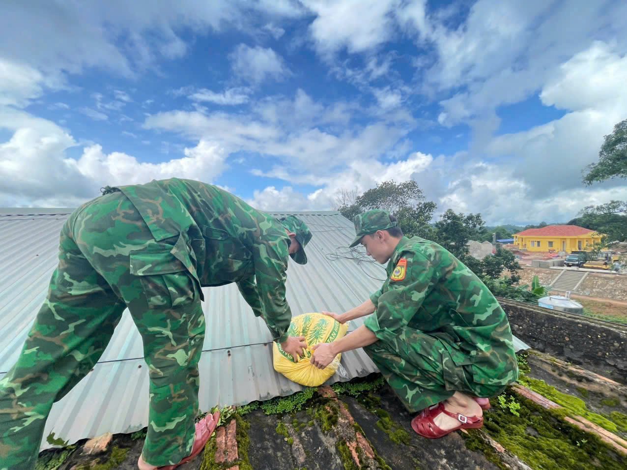 Lực lượng Bộ đội Biên phòng giúp dân chằng néo nhà cửa. Ảnh: T. Phùng.