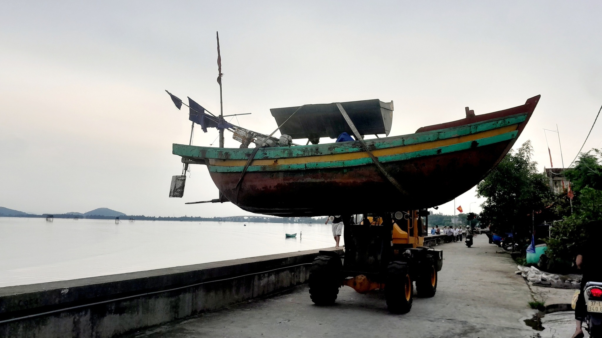Người dân dùng xe cẩu phương tiện tàu thuyền lên bờ tránh bão. Ảnh: Hữu Tình. Người dân dùng xe cẩu phương tiện tàu thuyền lên bờ tránh bão. Ảnh: Hữu Tình.