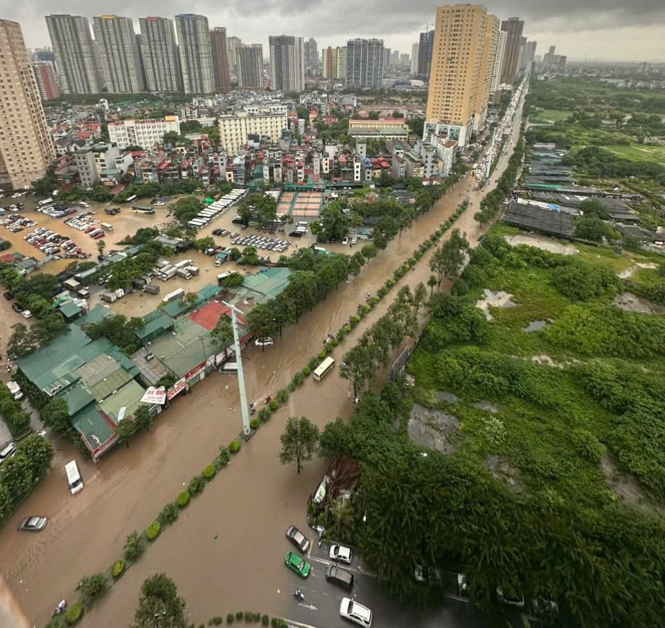 Đường Tố Hữu mênh mông biển nước. Hiện tại, nhiều cung đường đến trường bị ngập, nhiều trường học thông báo phụ huynh chủ động cho con nghỉ học. Ảnh: Minh Ngọc.