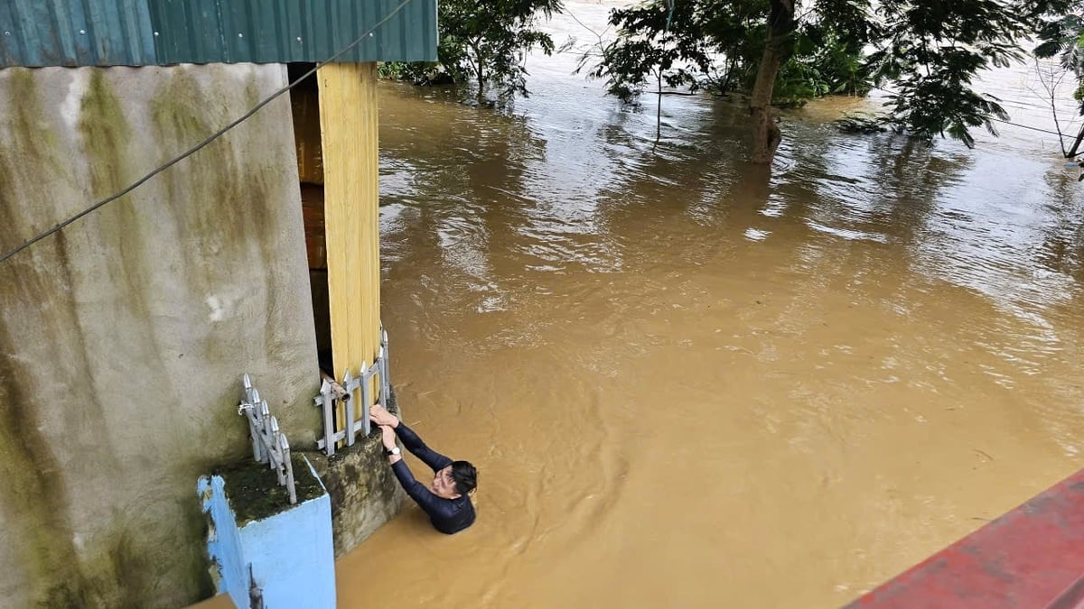 Trong dòng nước ngập sâu, con trai ông Thành đang cố tìm cách vào nhà để 'cứu' những vật dụng cần thiết. Trong dòng nước ngập sâu, con trai ông Thành đang cố tìm cách vào nhà để 'cứu' những vật dụng cần thiết.