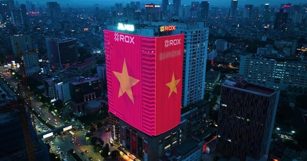 Trong đêm, ROX Tower nổi bật giữa lòng Hà Nội với màn hình LED cỡ lớn hiển thị lá cờ đỏ sao vàng, vừa là điểm nhấn thị giác vừa truyền cảm hứng yêu nước trong dịp kỷ niệm ngày lễ trọng đại của dân tộc. Trong đêm, ROX Tower nổi bật giữa lòng Hà Nội với màn hình LED cỡ lớn hiển thị lá cờ đỏ sao vàng, vừa là điểm nhấn thị giác vừa truyền cảm hứng yêu nước trong dịp kỷ niệm ngày lễ trọng đại của dân tộc.