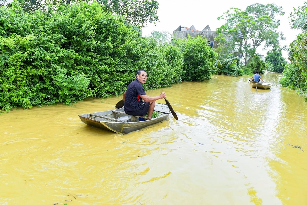Ông Mạo chèo thuyền trở về nhà kiểm tra dù nước lũ vẫn chưa rút. Ảnh: Thanh Tâm. Ông Mạo chèo thuyền trở về nhà kiểm tra dù nước lũ vẫn chưa rút. Ảnh: Thanh Tâm.