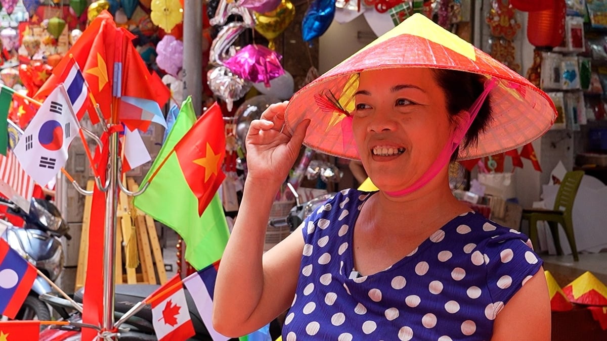 Bà Phạm Thị Hiền, chủ một cửa hàng lâu năm trên phố Hàng Mã đội thử chiếc nón cho khách hàng ngắm. Ảnh: Hà Trang. Bà Phạm Thị Hiền, chủ một cửa hàng lâu năm trên phố Hàng Mã đội thử chiếc nón cho khách hàng ngắm. Ảnh: Hà Trang.