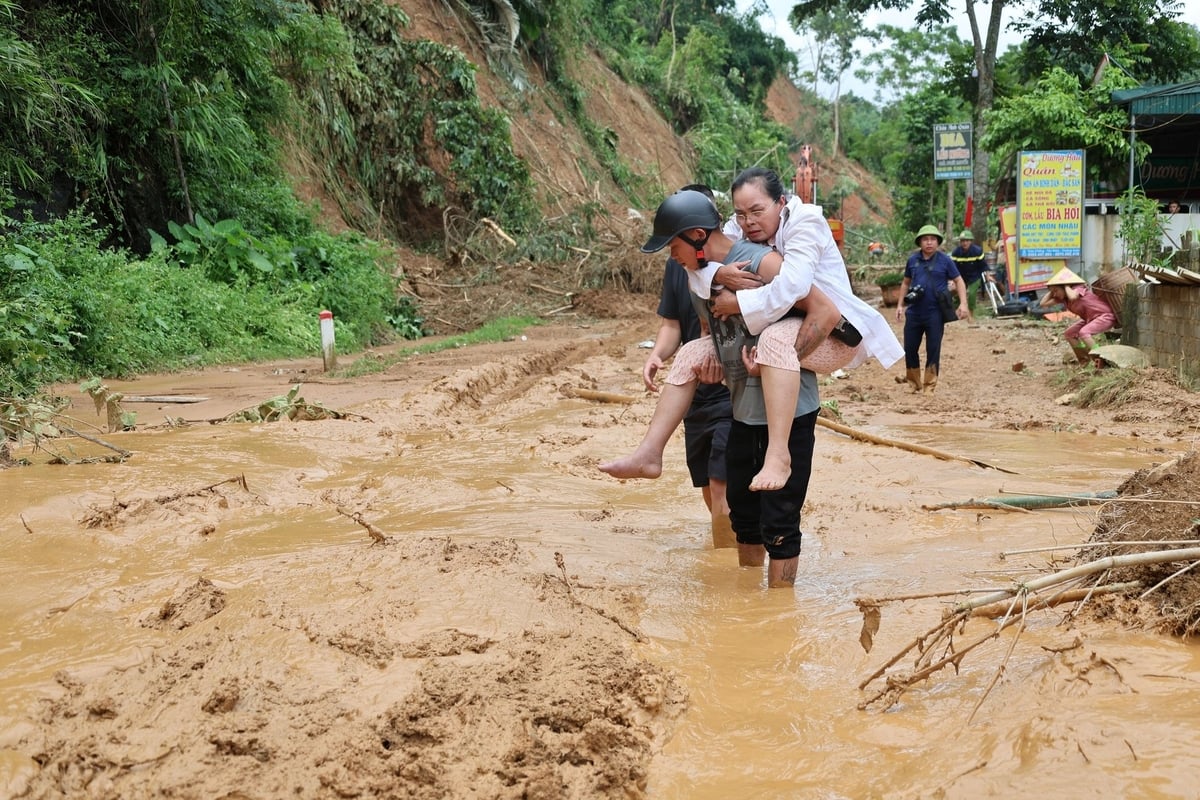 Một phụ nữ bị gãy chân, xe ô tô không vào được buộc người nhà phải cõng đi viện. Ảnh: Thanh Tâm. Một phụ nữ bị gãy chân, xe ô tô không vào được buộc người nhà phải cõng đi viện. Ảnh: Thanh Tâm.