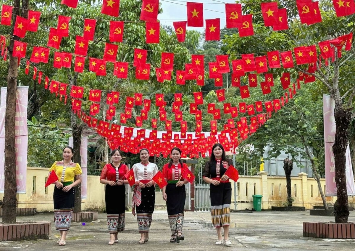Những cô gái Thái ở xã Hùng Chân, tỉnh Nghệ An rạng rỡ dưới giàn trang trí cờ Đảng, cờ Tổ quốc rất đẹp mắt chào mừng ngày Tết Độc lập - Quốc khánh 2/9. Ảnh: Thanh Đức.