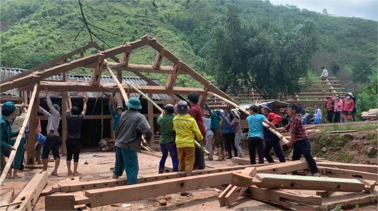 Lực lượng địa phương hỗ trợ người dân di chuyển nhà tránh nguy cơ sạt lở. Ảnh: H.C. 