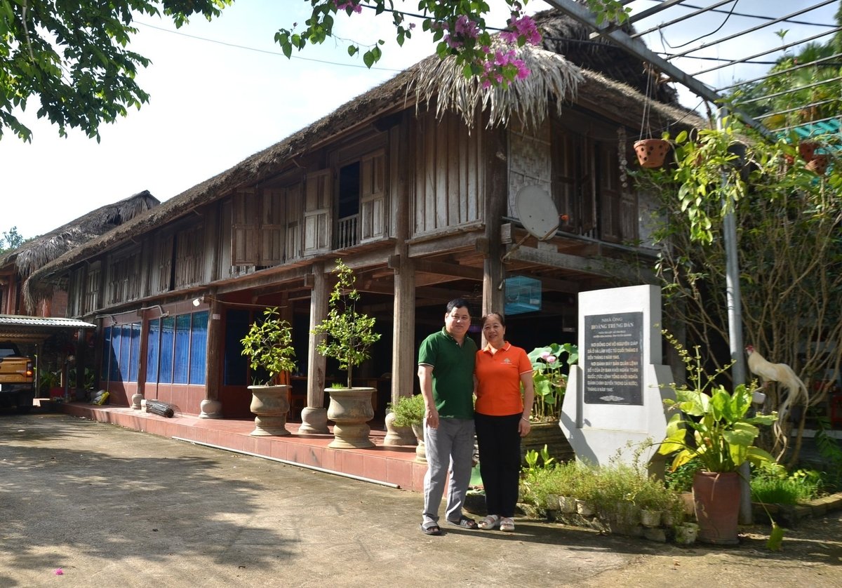 Vợ chồng anh Hoàng Văn Nhiên, cháu nội cụ Hoàng Trung Dân luôn giữ gìn ngôi nhà sàn lịch sử như giữ gìn báu vật của gia đình. Ảnh: Đào Thanh.