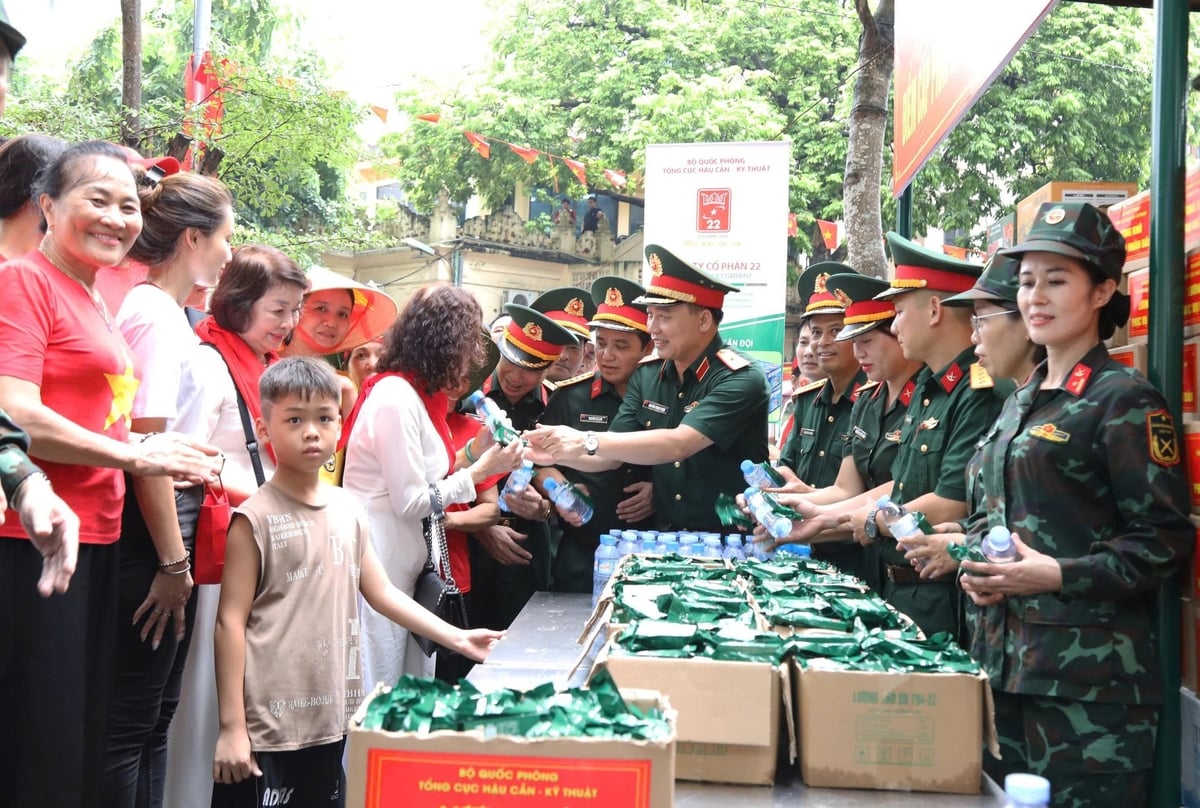Thiếu tướng Nguyễn Trọng Thiện cùng đoàn công tác Tổng cục Hậu cần – Kỹ thuật cấp phát lương khô tặng người dân tại vườn hoa Lê Trực. Ảnh: Quỳnh Hương.