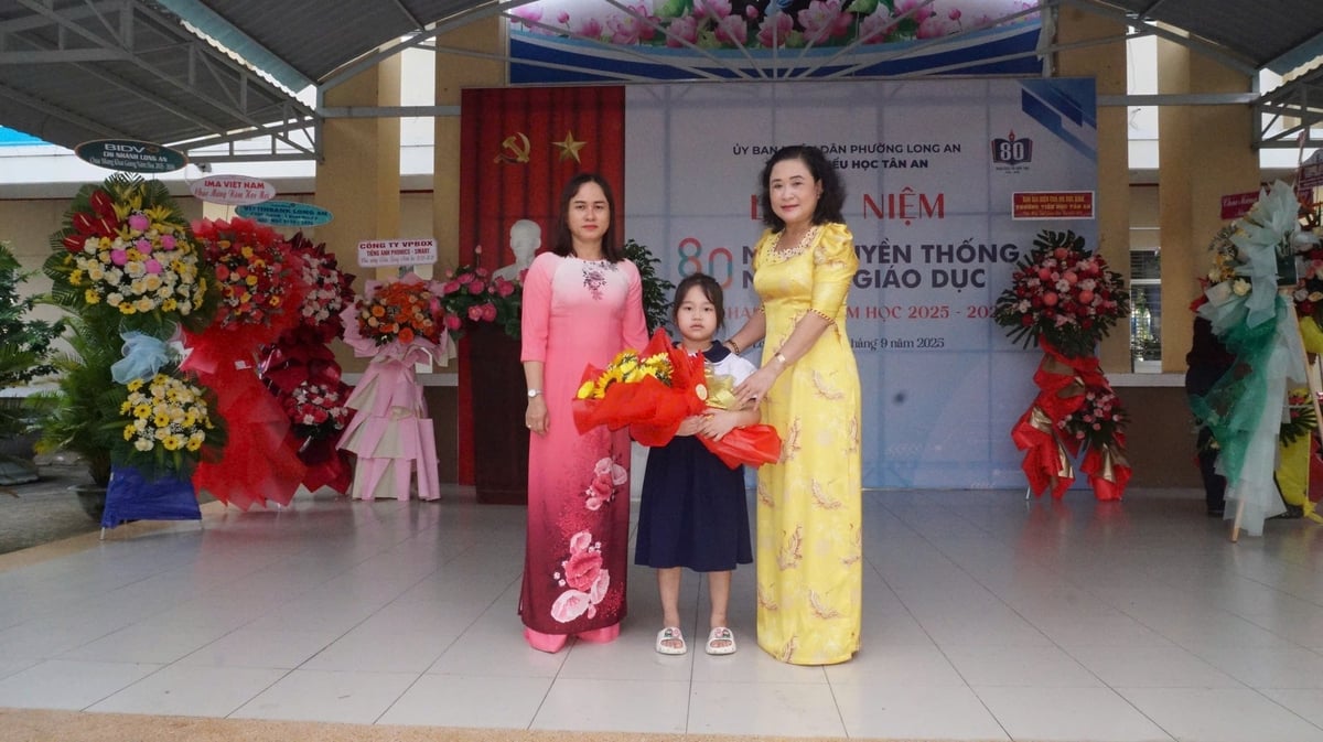 Bà Trần Thị Thi, Hiệu trưởng Trường Tiểu học Tân An (bìa phải) tặng hoa đại diện khối học sinh lớp 1. Ảnh: Trần Trung. Bà Trần Thị Thi, Hiệu trưởng Trường Tiểu học Tân An (bìa phải) tặng hoa đại diện khối học sinh lớp 1. Ảnh: Trần Trung.