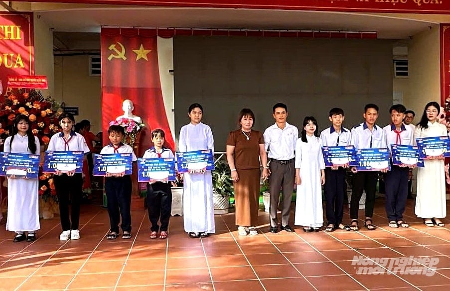 Đại diện Tập đoàn và đại lý chuyên phân phối sản phẩm thức ăn nuôi tôm thương hiệu GrowMax trên địa bàn xã Kiên Lương trao học bổng cho học sinh Trường THCS và PTTH Ba Hòn. Ảnh: Trung Chánh.