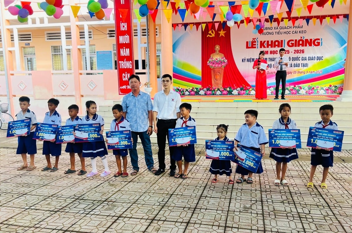 Anh Trương Chí Đại, Đại diện Tập đoàn GrowMax trao 10 suất học bổng cho các em học sinh Trường Tiểu học Cái Keo (xã Quách Phẩm). Ảnh: Trọng Linh.