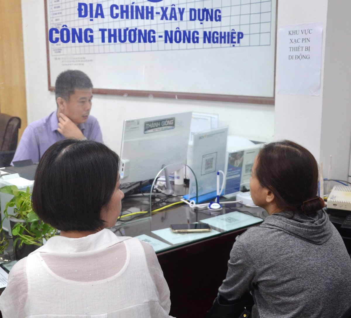 Cán bộ phường Vĩnh Tuy hướng dẫn và làm thủ tục hành chính về xây dựng cho người dân. Ảnh: Nguyễn Hà.
