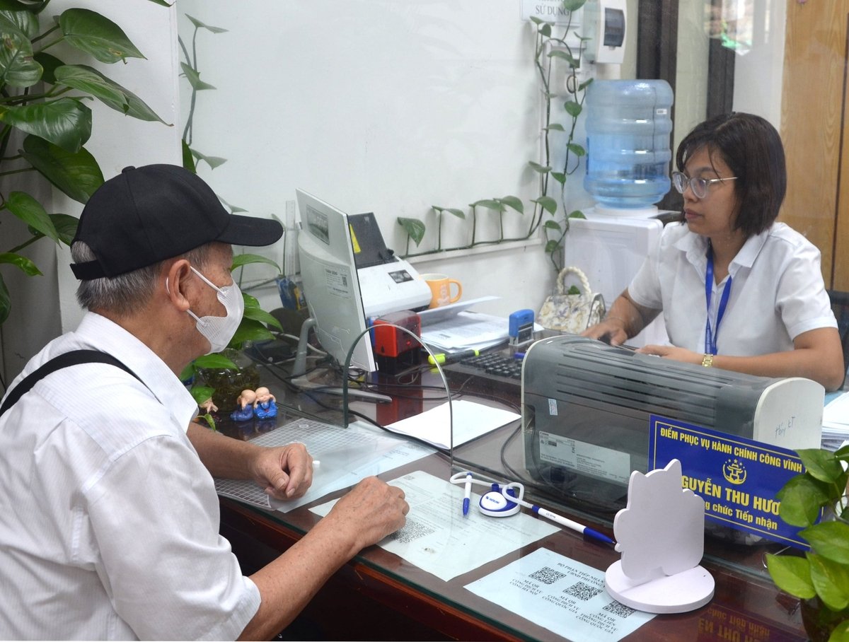 Cán bộ phường Vĩnh Tuy hướng dẫn và làm thủ tục hành chính về tư pháp cho người dân. Ảnh: Nguyễn Hà.