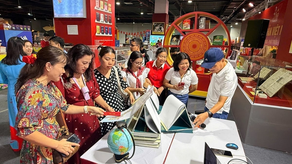 Người dân thích thú tìm hiểu sản phẩm bản đồ mới được ra mắt gồm bản đồ giấy và bản đồ điện tử. Ảnh: Ngọc Bích Người dân thích thú tìm hiểu sản phẩm bản đồ mới được ra mắt gồm bản đồ giấy và bản đồ điện tử. Ảnh: Ngọc Bích