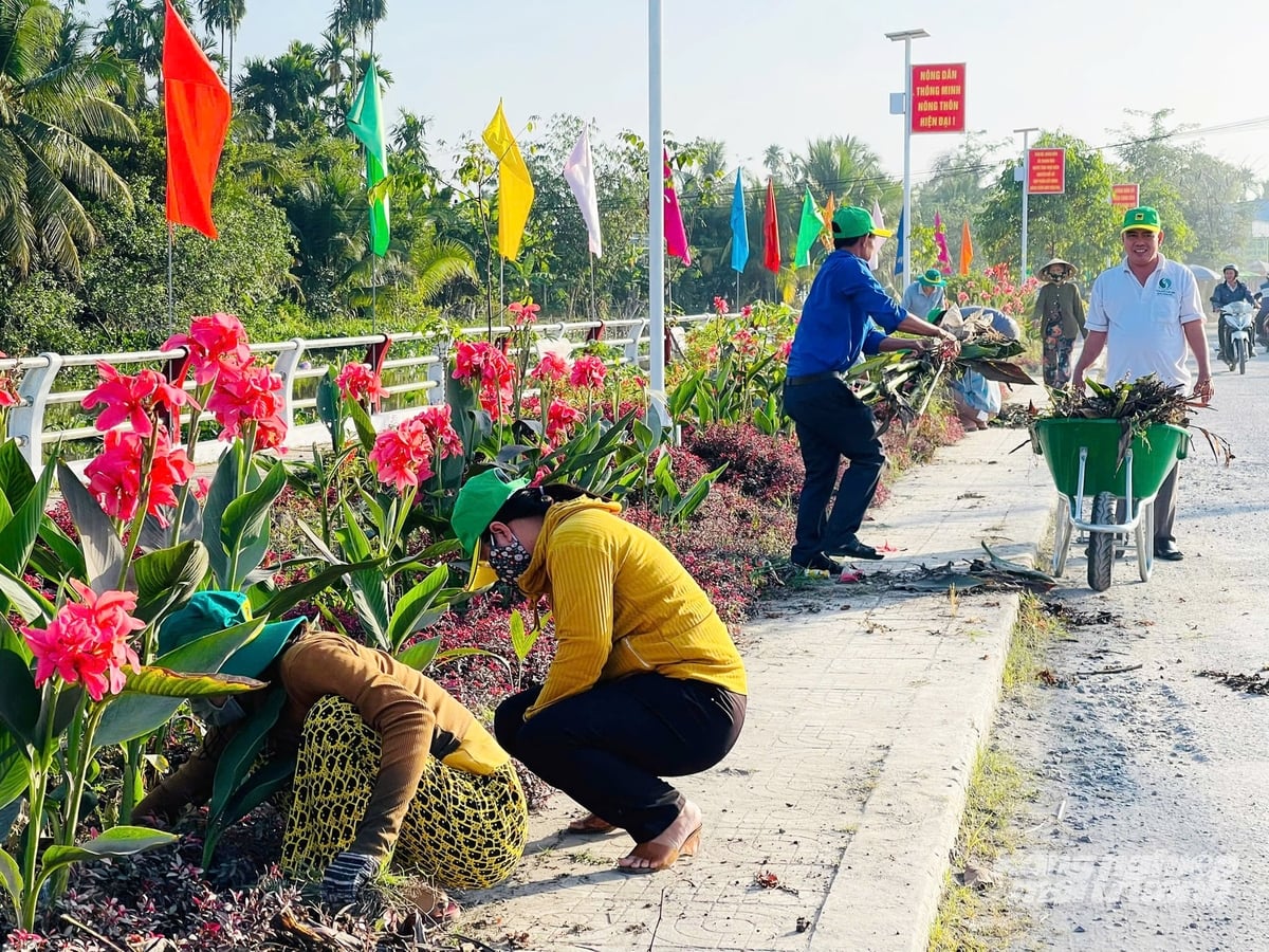 Ngay sau lễ phát động, các lực lượng ra quân dọn dẹp vệ sinh, chăm sóc bồn hoa, thu gom rác thải trên các tuyến đường, góp phần chỉnh trang cảnh quan nông thôn sáng, xanh, sạch, đẹp trước thềm Tết Nguyên đán. Ảnh: Lê Hoàng Vũ.