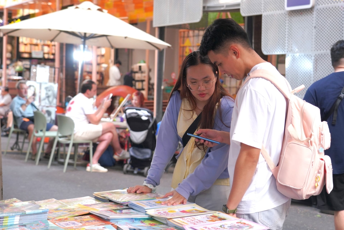 Người dân dừng chân lựa chọn sách và ấn phẩm văn hóa tại một gian hàng trên Đường Sách TP.HCM, nơi nhịp sống dường như chậm lại giữa những ngày cận Tết. Ảnh: Trần Phi.