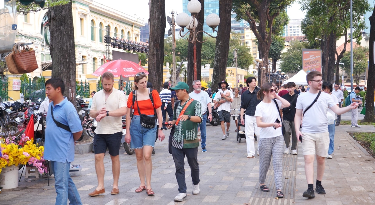 Người dân và du khách tản bộ trong khu vực công viên quanh Nhà thờ Đức Bà, chọn nhịp đi chậm để cảm nhận không khí Tết theo cách yên bình giữa trung tâm TP.HCM. Ảnh: Trần Phi.