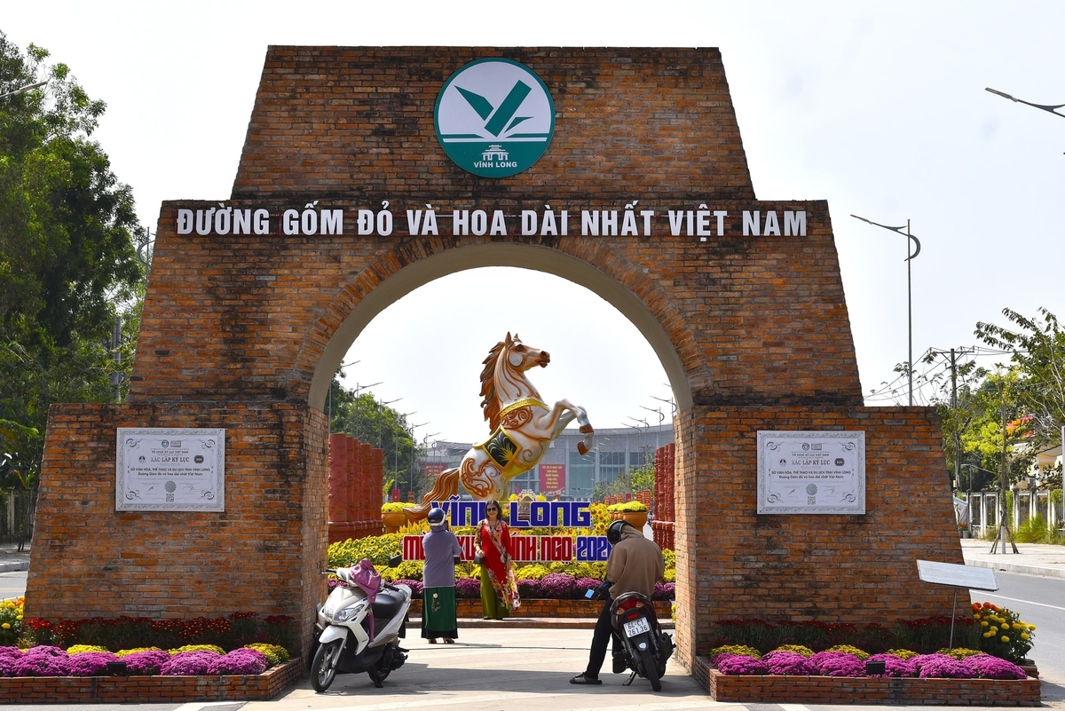 Du khách chụp hình tại đường Trần Văn Bảy - đường hoa xuân, đường gốm đỏ dài nhất Việt Nam. Ảnh: Minh Đảm.