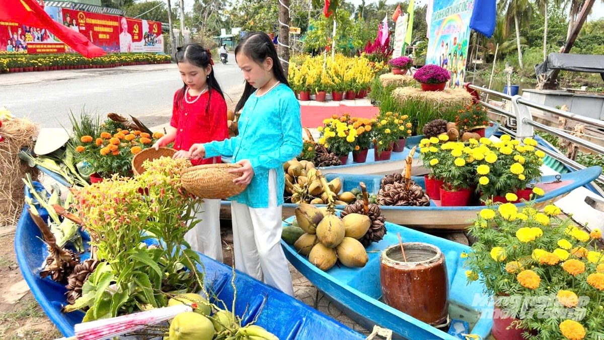 Thiếu nhi xã Thạnh Hòa trải nghiệm không gian tiểu cảnh chợ Tết quê với hoa xuân, trái cây và xuồng ba lá được bài trí rực rỡ mừng Đảng, mừng Xuân Bính Ngọ 2026. Ảnh: Lê Hoàng Vũ.