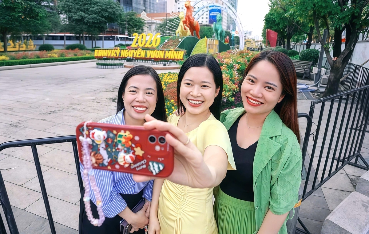 Người dân tranh thủ chụp ảnh lưu niệm tại khu vực Đường hoa Nguyễn Huệ khi không gian xuân đã dần hoàn chỉnh trước ngày khai mạc. Ảnh: Trần Phi.