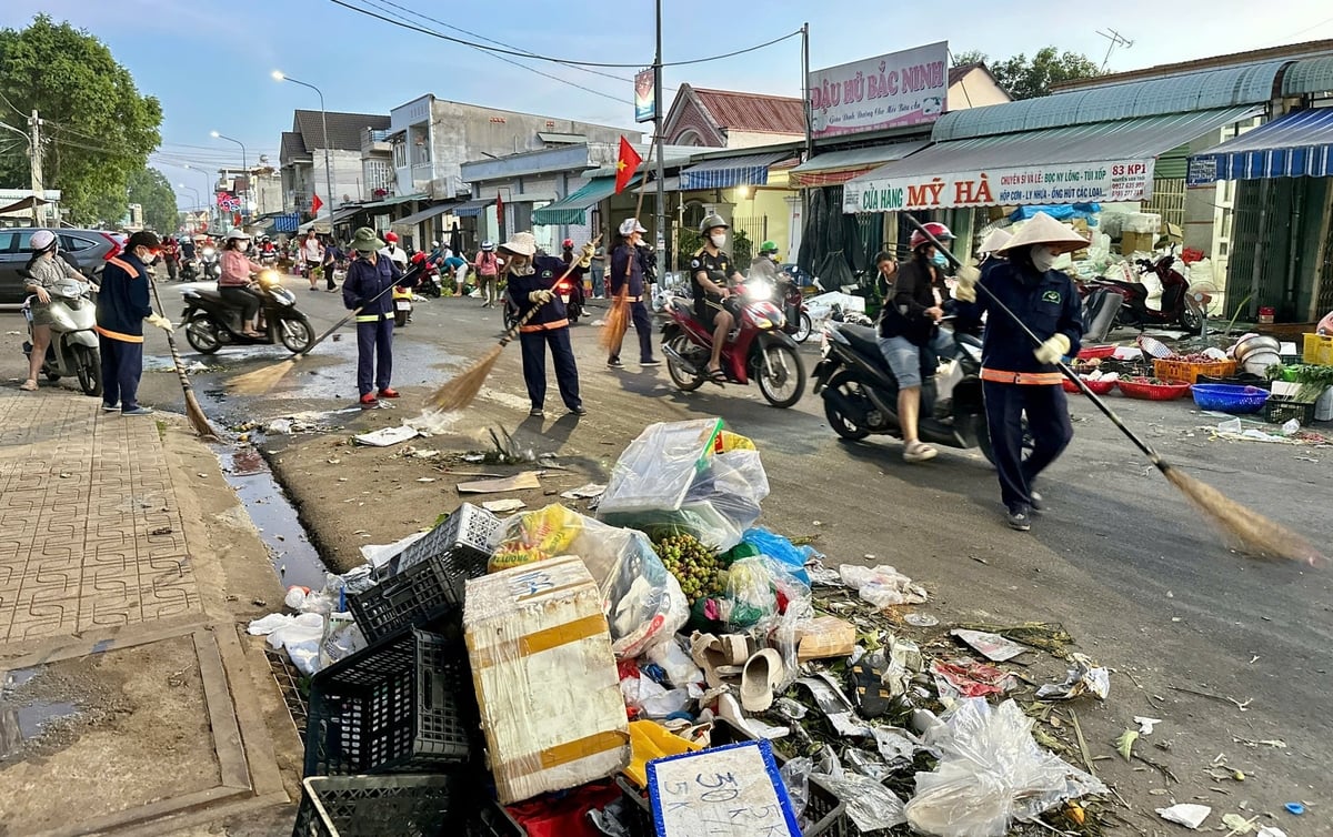 Rác thải chất đầy sau giờ tan chợ vào chiều 29 Tết, nhưng chỉ ít phút sau, những nhịp chổi quen thuộc của công nhân môi trường lại lặng lẽ làm sạch từng mét đường, trả lại diện mạo gọn gàng cho Phú Giáo trong đêm cận Tết. Ảnh: Minh Duy.
