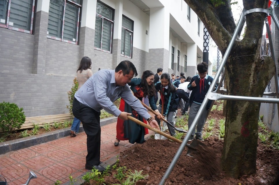 Ông Nguyễn Anh Dũng - Phó Chủ tịch UBND phường Giảng Võ cùng lãnh đạo và học sinh Trường THCS Giảng Võ 2 trồng cây xanh. Ảnh: Lan Chi.