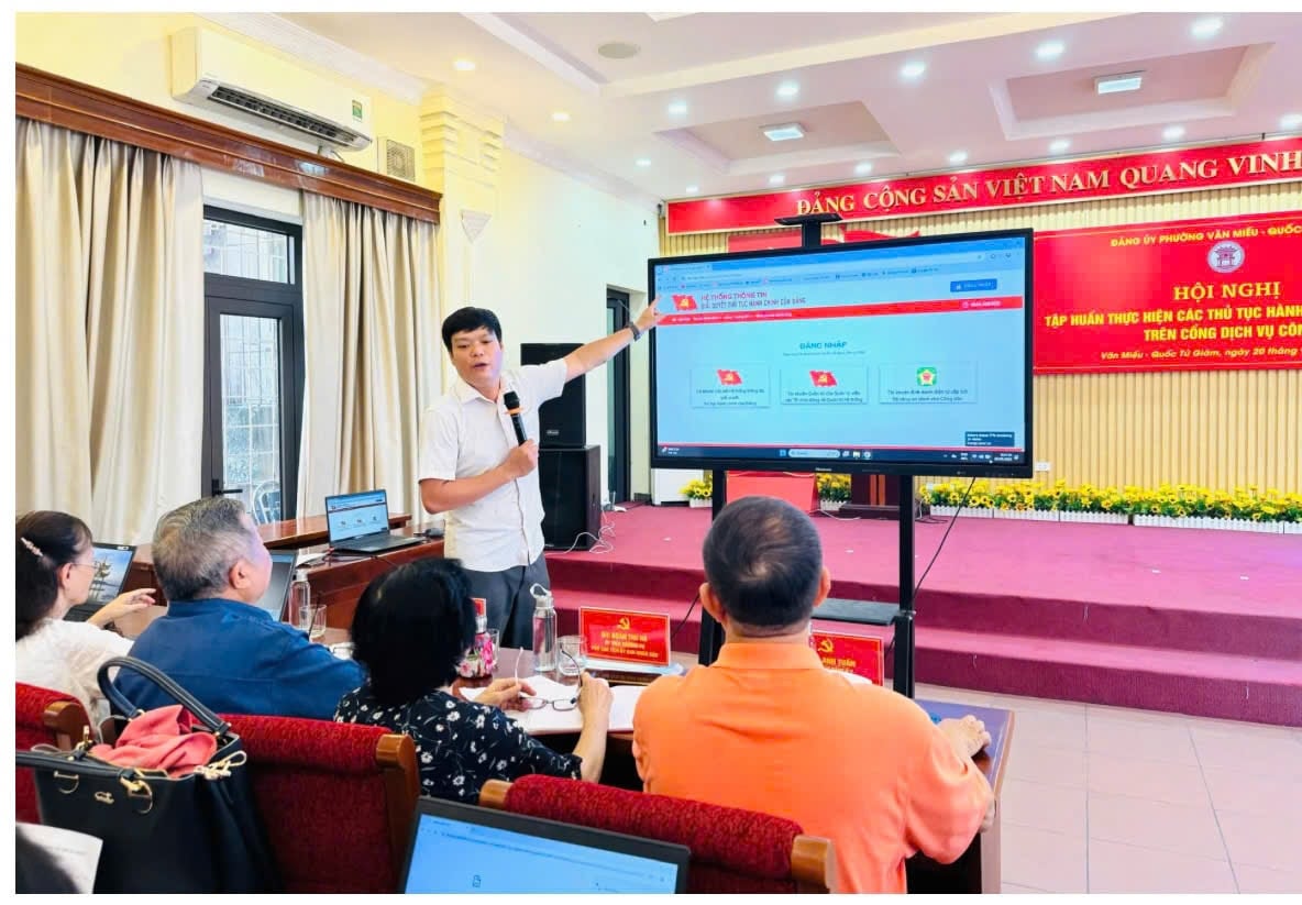 Cán bộ Văn phòng Đảng ủy phường Văn Miếu – Quốc Tử Giám hướng dẫn Bí thư chi bộ và đảng viên cài đặt, sử dụng phần mềm giải quyết thủ tục hành chính của Đảng. Ảnh: Hanoimoi.