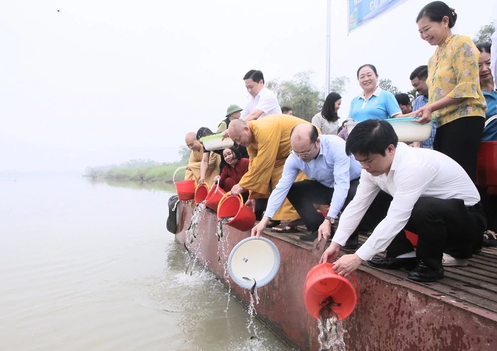 Phó Chủ tịch UBND tỉnh Thanh Hóa Cao Văn Cường và các đại biểu thả cá giống xuống lưu vực sông Mã. Ảnh: Lê Hòa.