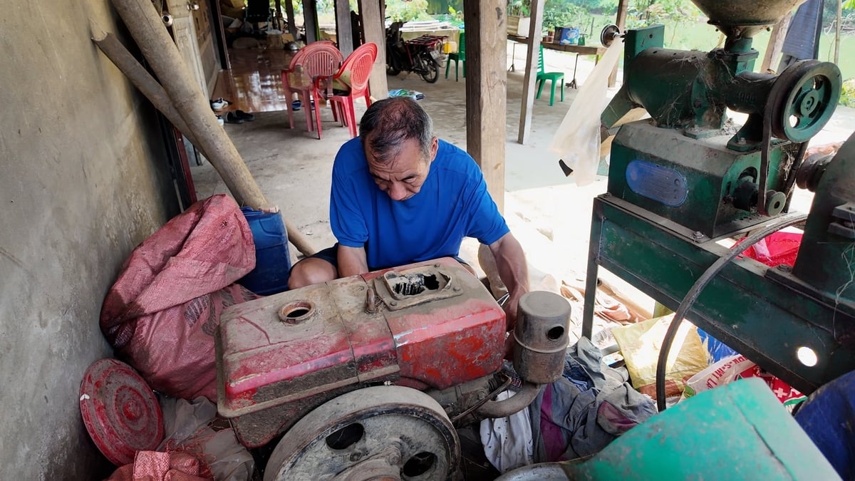 Ông Giang sửa chữa đầu máy nổ để phát điện phục vụ sinh hoạt của gia đình. Ảnh: Ngọc Tú.