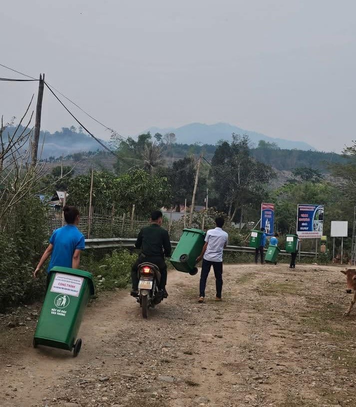 Cán bộ, đoàn thể và người dân xã Thanh Yên vận chuyển thùng rác đến các hộ gia đình tại bản Pa Thơm, góp phần cải thiện vệ sinh môi trường nông thôn. Ảnh: CTV. 