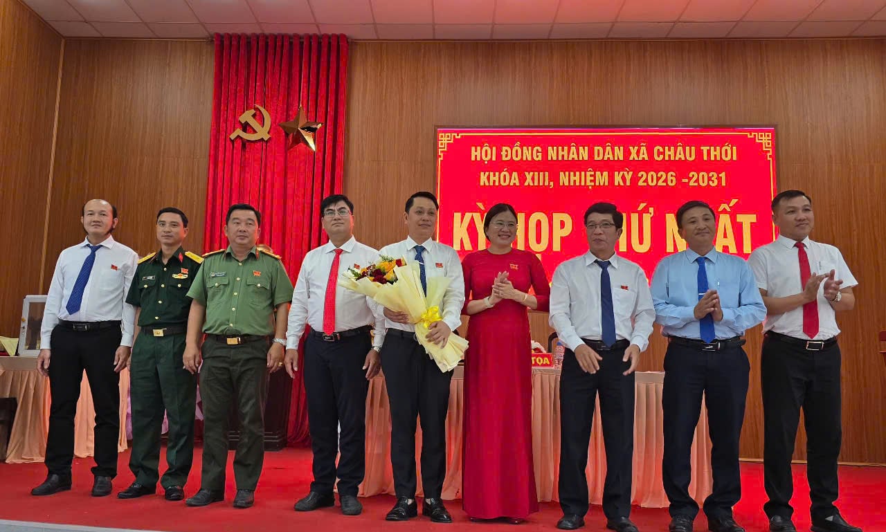 Bà Trương Ngọc Thảo, Bí thư Đảng ủy, Chủ tịch HĐND xã Châu Thới tặng hoa chúc mừng ông Nhan Chí Nguyễn, giữ chức Chủ tịch UBND xã Châu Thới cùng các thành viên Ủy viên nhân dân xã, nhiệm kỳ 2026-2031. Ảnh: Trọng Linh.