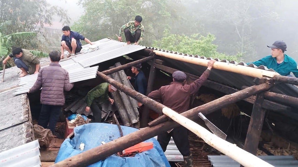 Người dân Xín Mần hỗ trợ nhau lợp lại mái nhà sau khi bị tốc mái bởi gió lốc. Ảnh: Huyền An. 