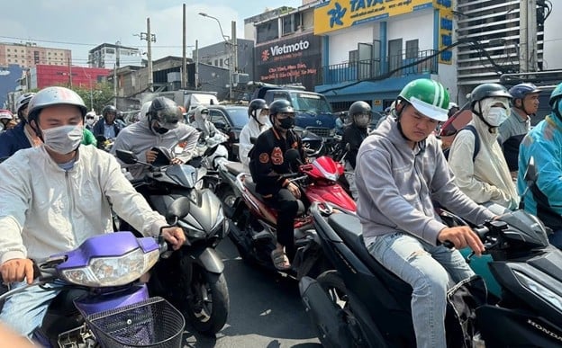 Người dân TP.HCM che chắn kỹ với áo khoác, khẩu trang khi di chuyển trên đường dưới cái nắng như đổ lửa. Ảnh: Hà Duyên.