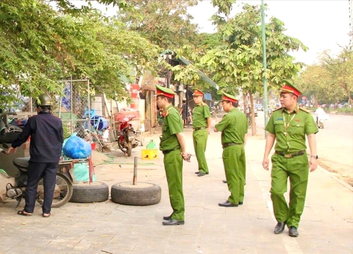 Lực lượng chức năng phường Phú Thượng kiểm tra, xử lý tình trạng lấn chiếm vỉa hè. Ảnh: Tiến Trung.