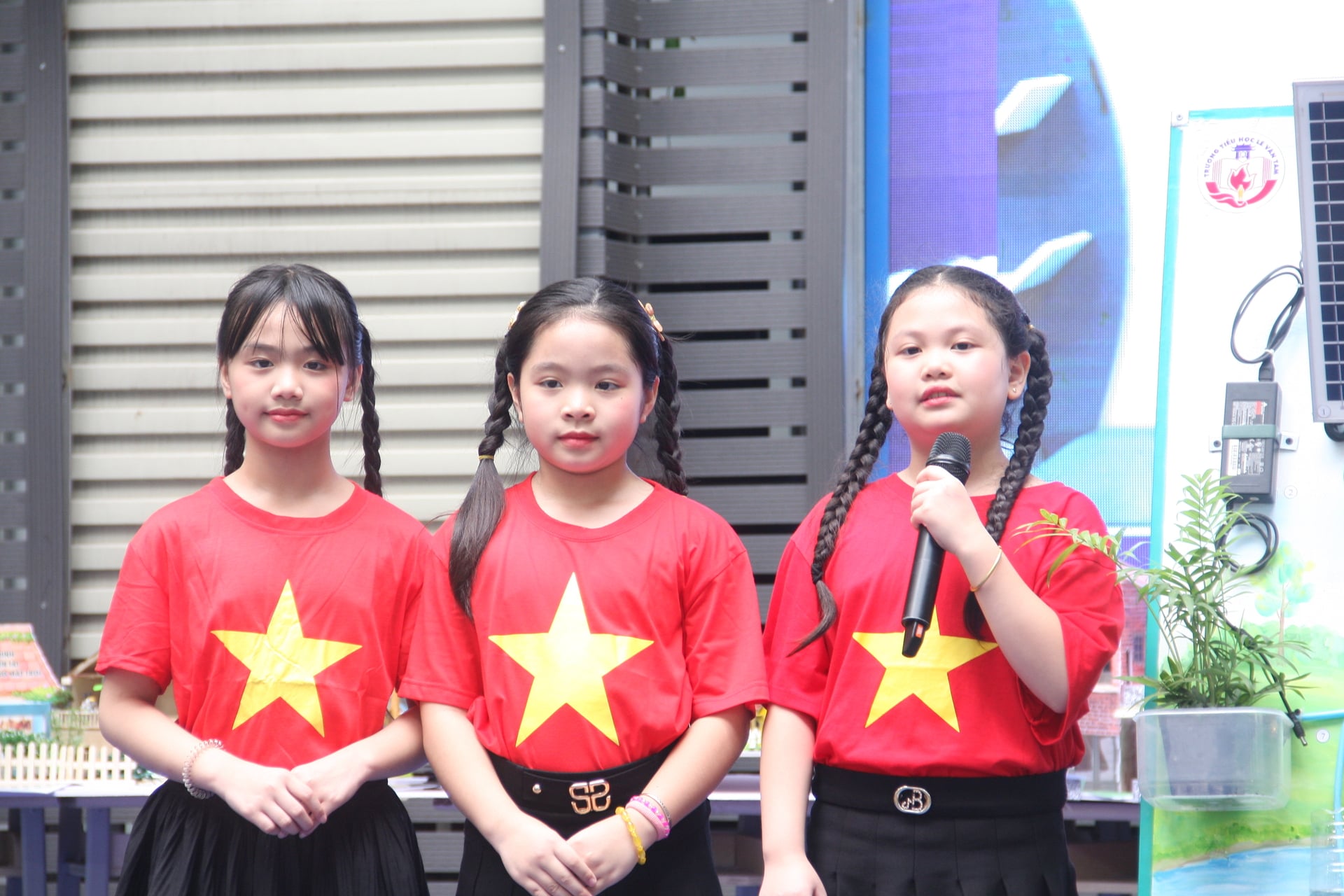 Em Đinh Hà Đan, học sinh lớp 3A5 Trường Tiểu học Lê Văn Tám cùng các bạn trong nhóm tự tin thuyết trình sản phẩm 'Mô hình năng lượng xanh tái tạo nguồn sống'. Ảnh: Mai Đan.
