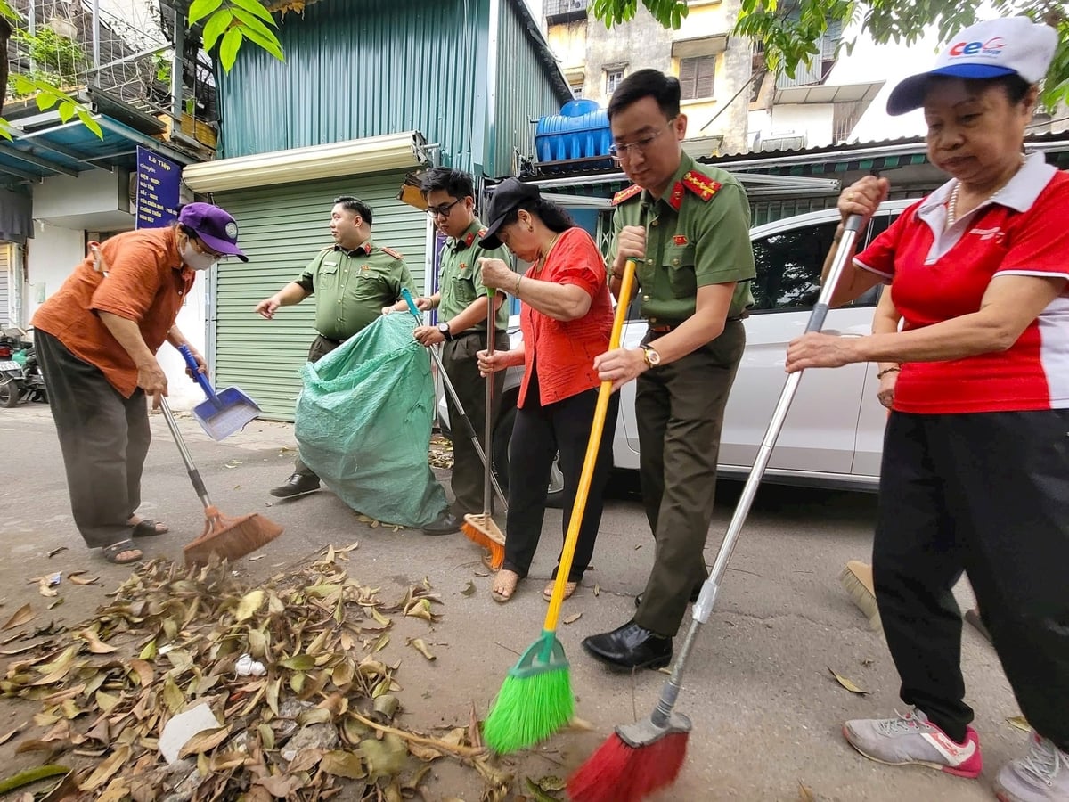 Cán bộ, chiến sĩ Phòng An ninh Kinh tế (Công an thành phố Hà Nội), Công an phường Giảng Võ, Phòng Kinh tế Hạ tầng và Đô thị Giảng Võ cùng người dân dọn vệ sinh môi trường tại khu dân cư. Ảnh: Thành Tiến.