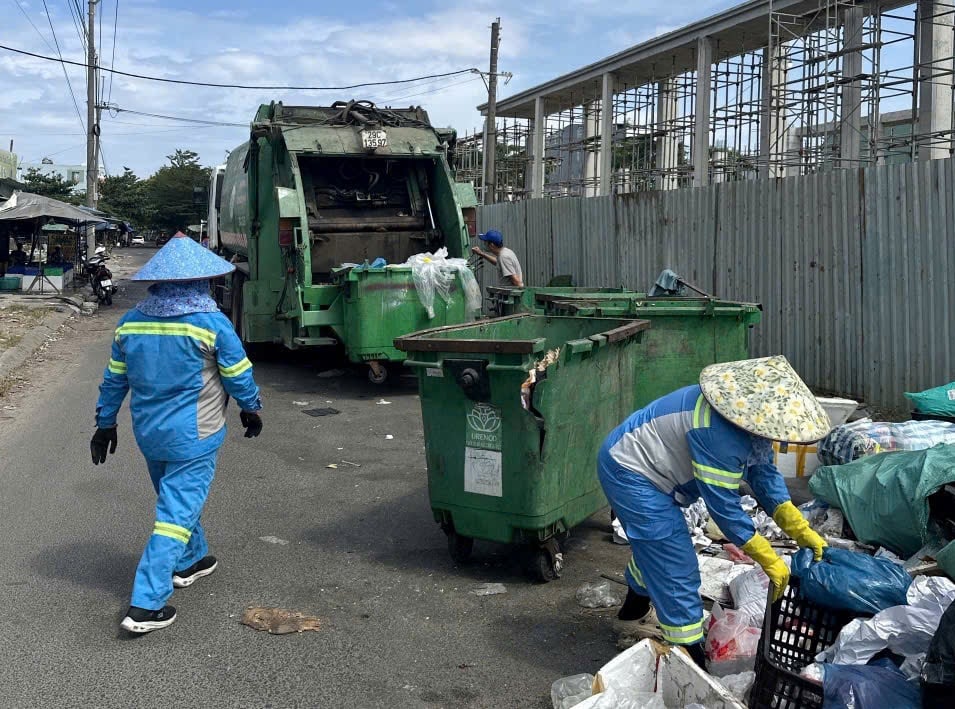 Lực lượng vệ sinh môi trường thu gom rác tại điểm tập kết tự phát trên đường Lê Văn Miến. Ảnh: L.Q.