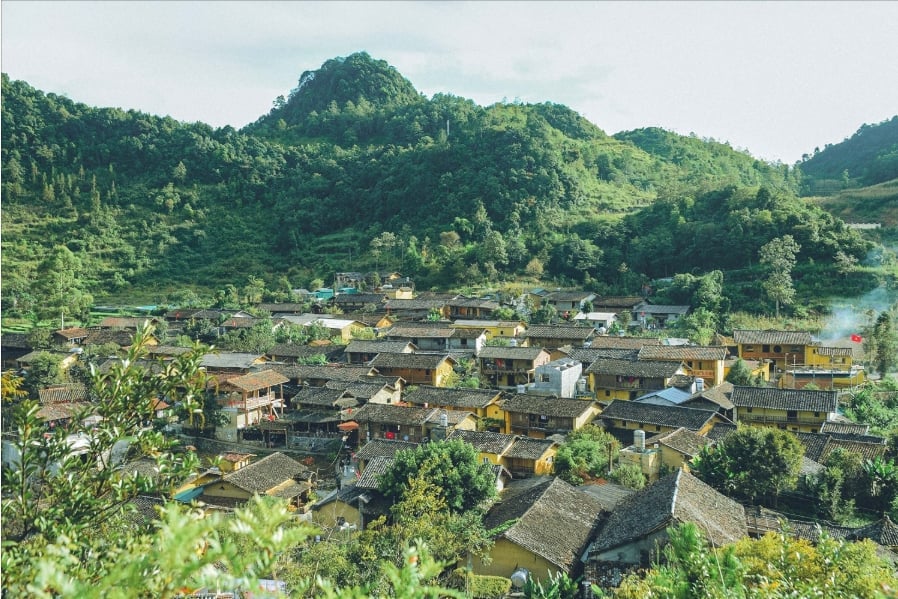 Làng Lô Lô Chải nép mình dưới chân Cột cờ Lũng Cú, nổi bật với những ngôi nhà trình tường mái ngói âm dương và sắc màu trang phục truyền thống rực rỡ của đồng bào Lô Lô. Ảnh: Vũ Mừng.