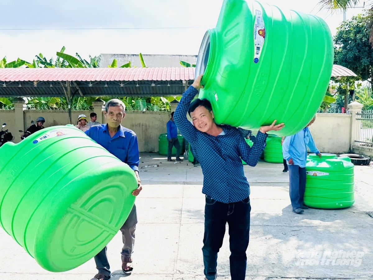 Người dân xã Trường Xuân phấn khởi vận chuyển bồn chứa nước về nhà sau lễ trao tặng trong chương trình hỗ trợ cộng đồng của Tập đoàn Tân Á Đại Thành và Báo Nông nghiệp và Môi trường. Ảnh: Lê Hoàng Vũ.