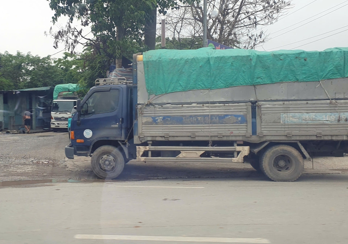 Hai xe tải từ công trường nối đuôi nhau chờ cân tải trọng tại phố Miêu Nha, phường Xuân Phương. Ảnh: Quán Dũng.