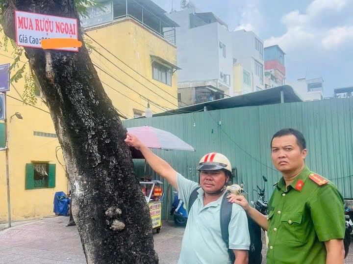 Công an phường Nhiêu Lộc yêu cầu người vi phạm tháo gỡ biển quảng cáo sai qui định. Ảnh: Nhiêu Lộc. 