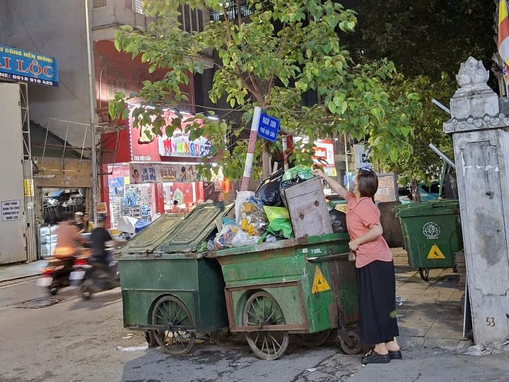 Khoảng 19h tối, người dân ở đầu ngõ 209 Đội Cấn thường chủ động mang rác ra điểm tập kết gần nhà. Ảnh: Mai Đan.