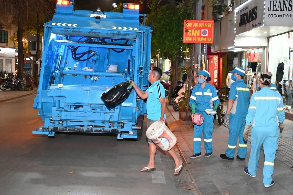 Công nhân môi trường thu gom rác tại phường Ba Đình sau 20 giờ, giảm áp lực ùn ứ trên các tuyến phố nội đô. Ảnh: Thu Trang.