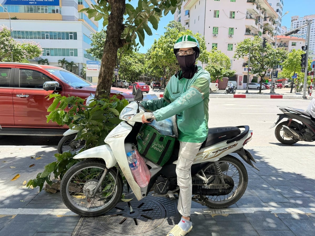 Anh Nguyễn Văn Minh - shipper phải uống nhiều nước liên tục và nghỉ làm sớm để bảo đảm sức khỏe. Ảnh: Trung Nguyên. 