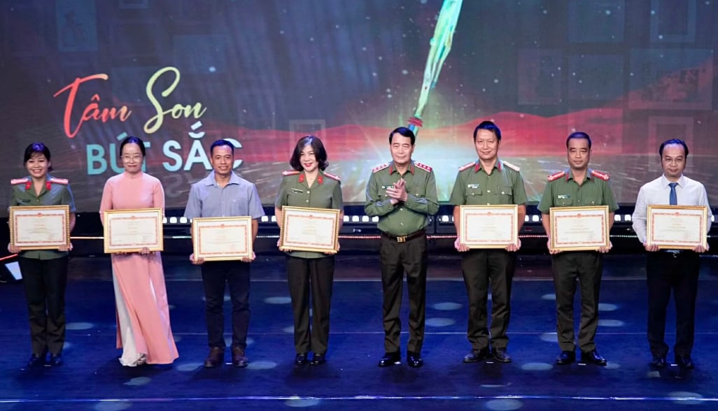 Thứ trưởng Lê Quốc Hùng trao Bằng khen của Bộ Công an tặng các tập thể, cá nhân có thành tích xuất sắc trong công tác tuyên truyền, báo chí. Ảnh: Báo CAND.