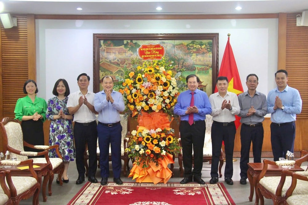 Phó Giám đốc Thường trực Học viện Chính trị Quốc gia Hồ Chí Minh Lê Hải Bình tặng hoa chúc mừng Bộ VHTTDL. Ảnh: Đình Toán.
