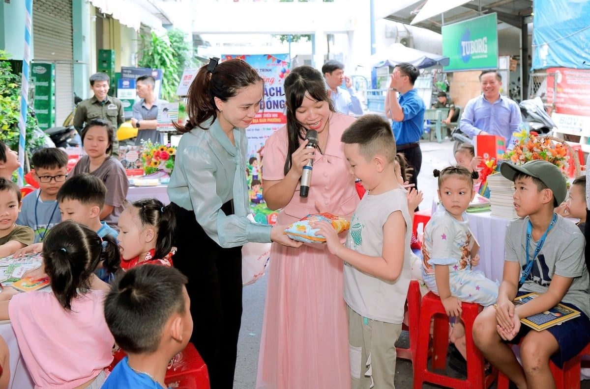 Tặng quà cho những độc giả nhí của 'Tủ sách cộng đồng' ở khu nhà trọ. Ảnh: SVH.