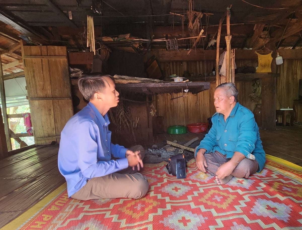 Ông Đinh Văn Rít (bên phải) trò chuyện với tác giả bên bếp trong nhà sàn. Ảnh: Việt Hòa.